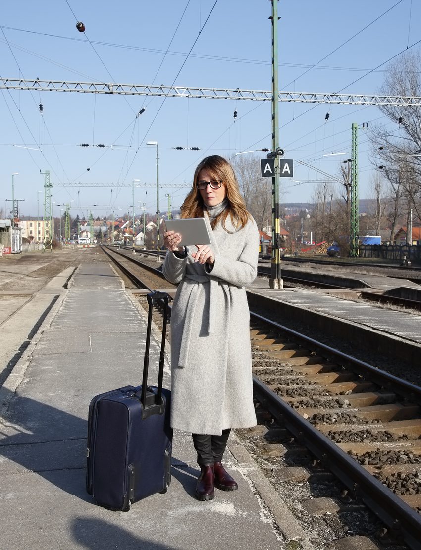 Reisende mit Koffer am Bahnsteig